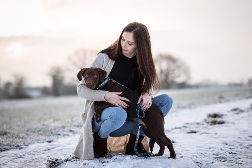 Frau mit Welpe bei Hundefotoshooting im Schnee mit Coralie Duda Fotografie im Wetteraukreis