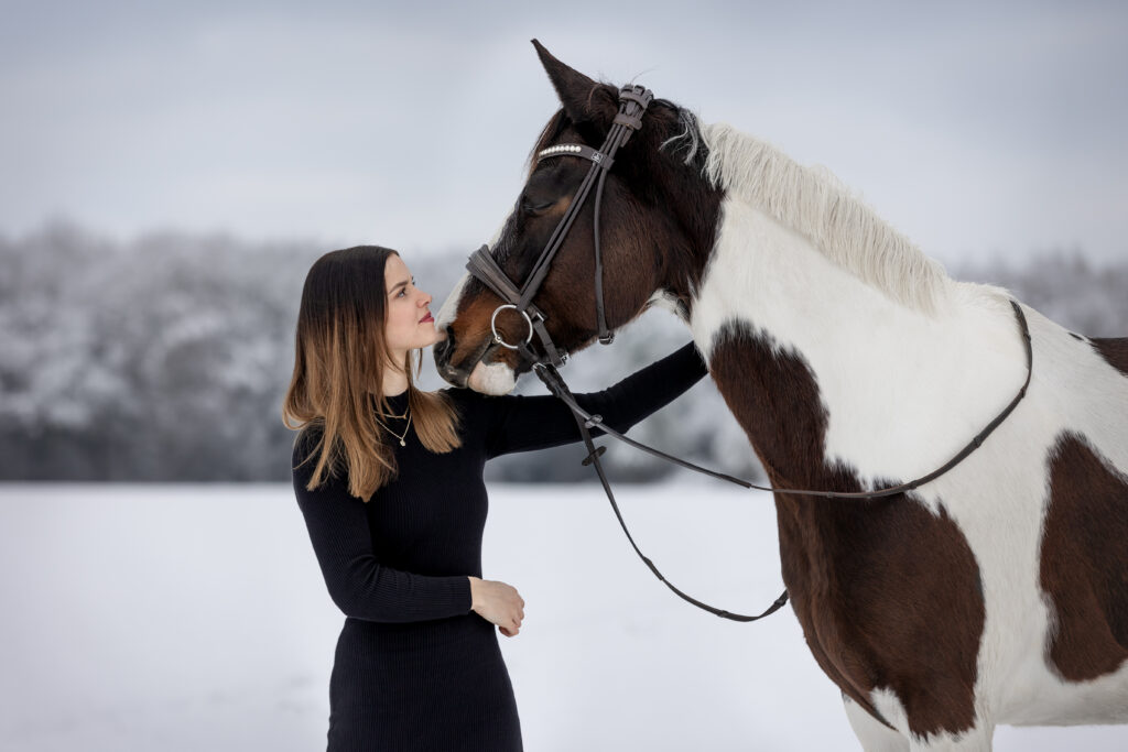 Frau mit Pferd bei Fotoshooting im Schnee mit Coralie Duda Fotografie im Main-Kinzig-Kreis