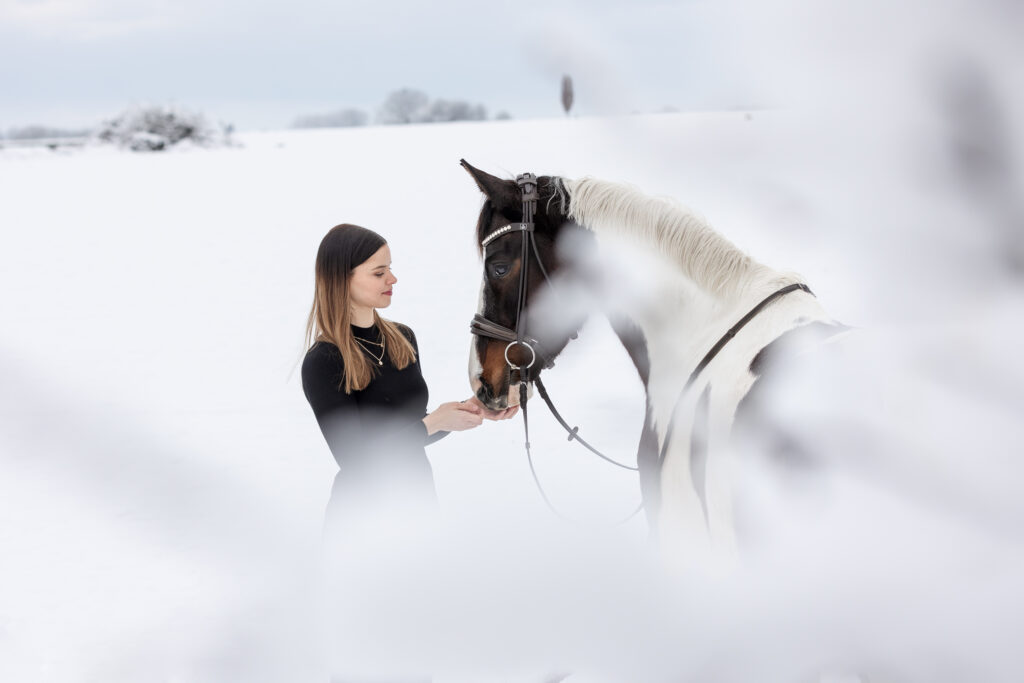 Frau mit Pferd bei Fotoshooting im Winter mit Coralie Duda Fotografie im Main-Kinzig-Kreis