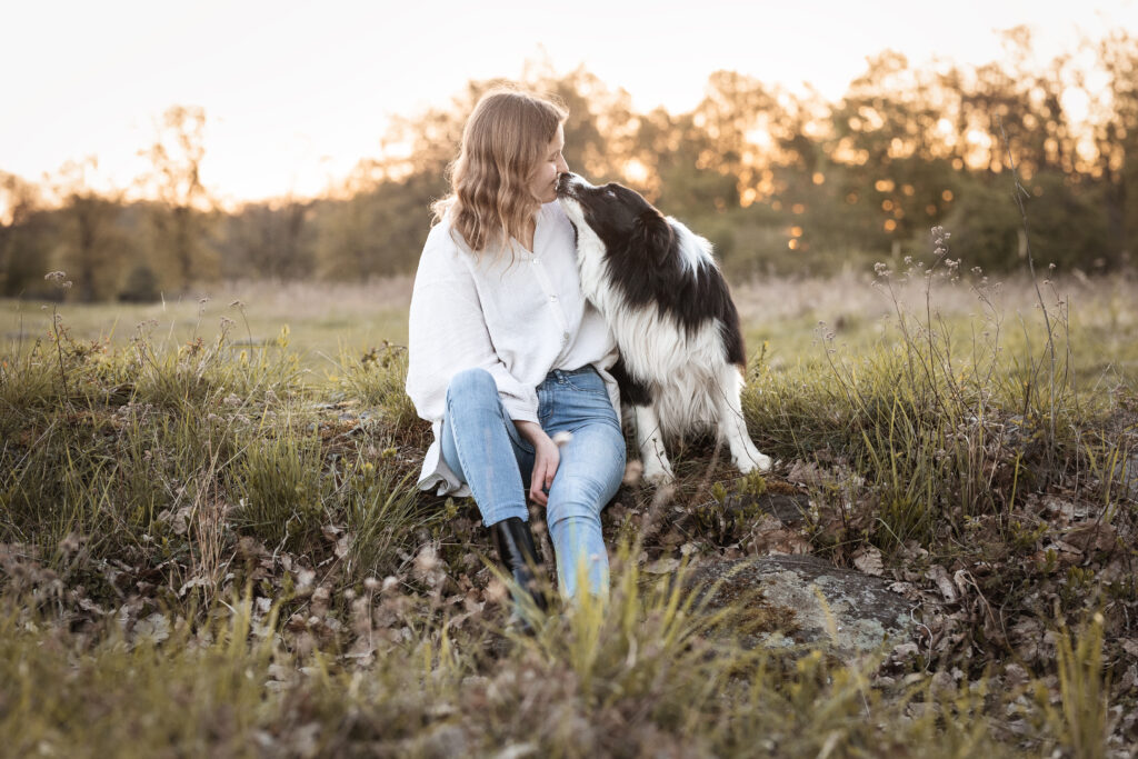 Bordercollie küsst Frau bei Hundefotoshooting mit Tierfotografin Coralie Duda Fotografie