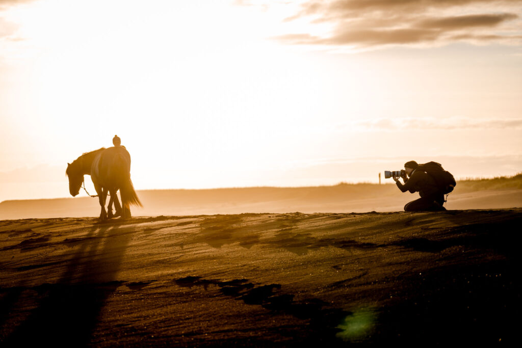 Coralie Duda Fotografie bei Pferdefotoshooting im Sonnenuntergang am schwarzen Strand in Island