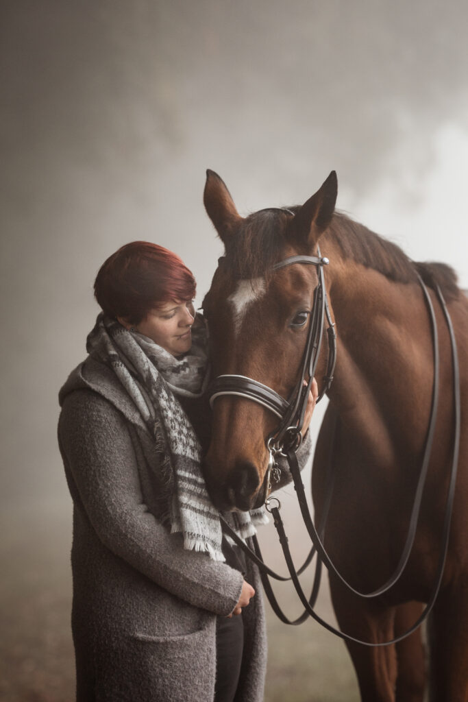 Frau kuschelt Pferd bei Nebelfotoshooting im Herbst mit Coralie Duda Fotografie im Wetteraukreis