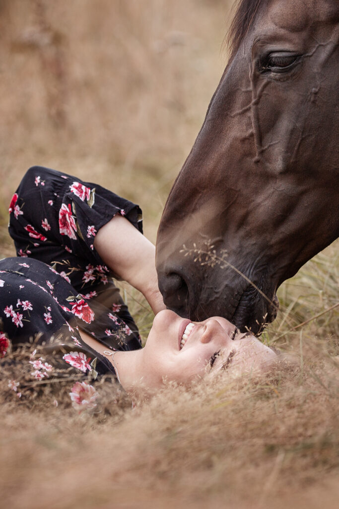 Frau liegend mit Pferd bei Fotoshooting im Sommer mit Coralie Duda Fotografie im Wetteraukreis