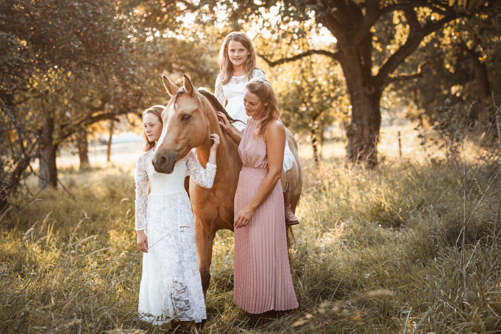 Familienfoto mit Pferd bei Fotoshooting im Sonnenuntergang mit Coralie Duda Fotografie im Wetteraukreis