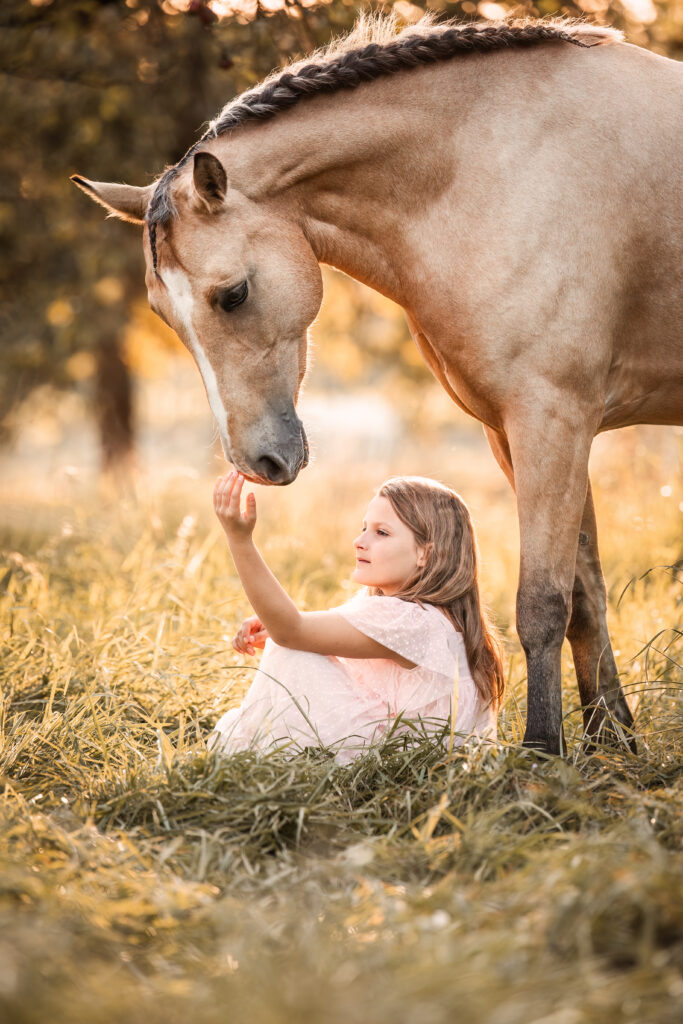 sitzendes Mädchen mit Pony bei Pferdefotoshooting im Sommer mit Coralie Duda Fotografie im Wetteraukreis