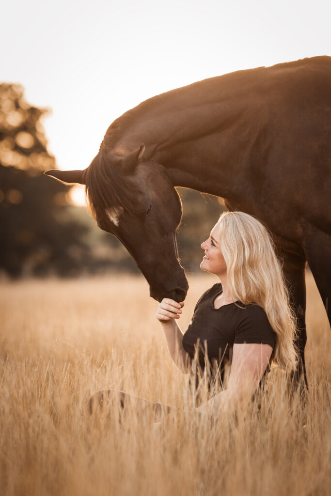 Frau vor Pferd sitzend bei Fotoshooting mit Coralie Duda Fotografie im Wetteraukreis