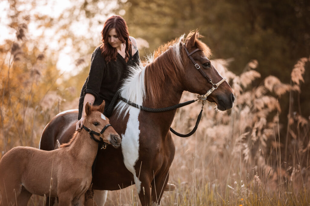 Frau auf Pferd mit Fohlen bei Fohlenfotoshooting mit Pferdefotografin Coralie Duda Fotografie