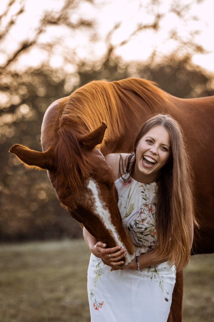 Frau lacht und kuschelt Pferd bei Fotoshooting mit Coralie Duda Fotografie im Wetteraukreis