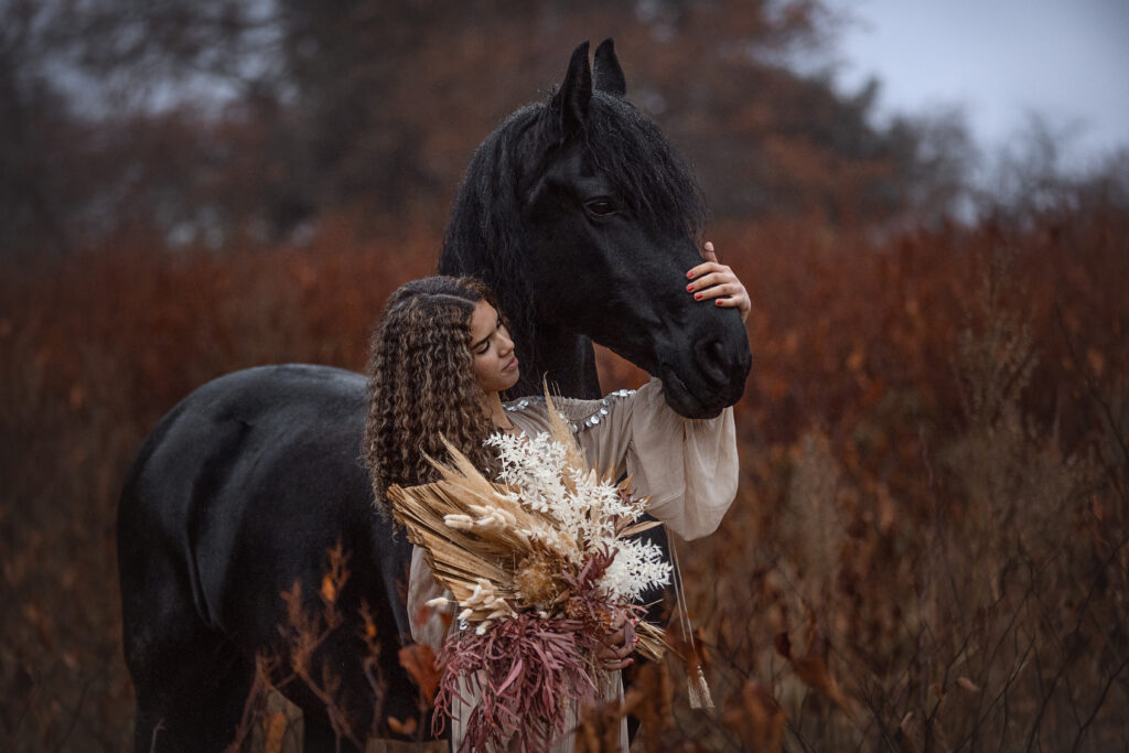 Friese Pferd mit Frau im Boho Stil bei Fotoshooting im Herbst mit Coralie Duda Fotografie im Wetteraukreis