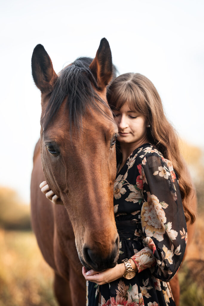 Frau kuschelt Pferd bei Fotoshooting im Herbst mit Coralie Duda Fotografie im Wetteraukreis